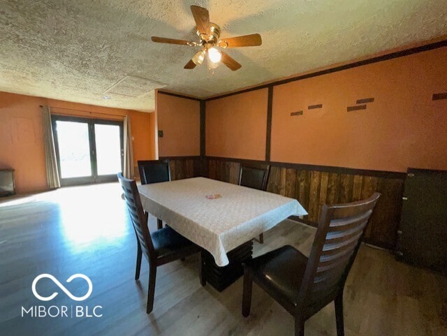 1998 Crescent St, Franklin, IN 46131 - dining area featuring a textured ceiling, wood finished floors, ceiling fan, and a wainscoted wall