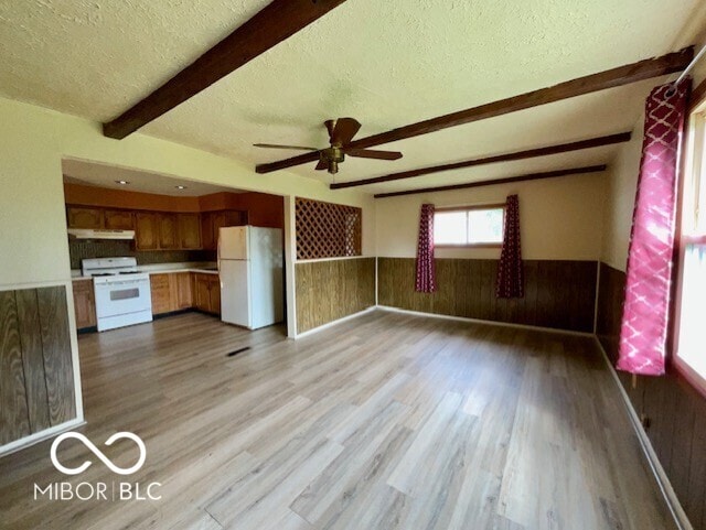 1998 Crescent St, Franklin, IN 46131 - kitchen featuring white appliances, beamed ceiling, a textured ceiling, under cabinet range hood, and brown cabinetry