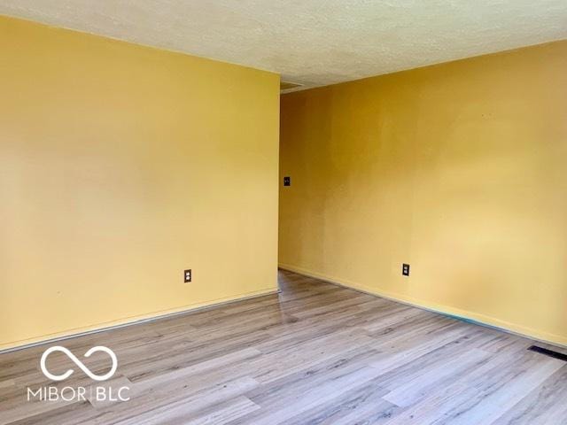 1998 Crescent St, Franklin, IN 46131 - spare room featuring wood finished floors, a textured ceiling, and baseboards