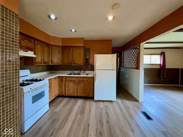 1998 Crescent St, Franklin, IN 46131 - kitchen featuring white appliances, under cabinet range hood, light wood finished floors, a sink, and light countertops