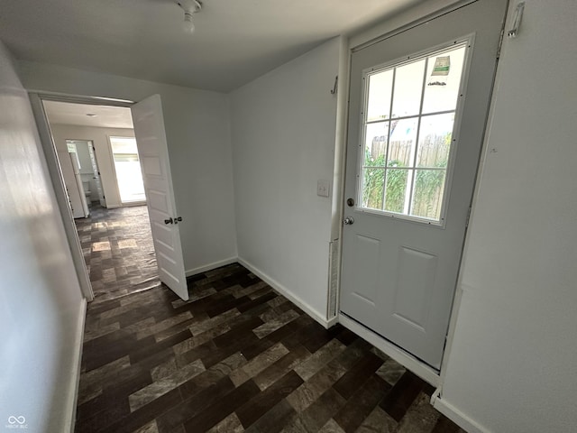 2310 E Raymond St, Indianapolis, IN 46203 - doorway to outside featuring dark wood finished floors, healthy amount of natural light, and baseboards