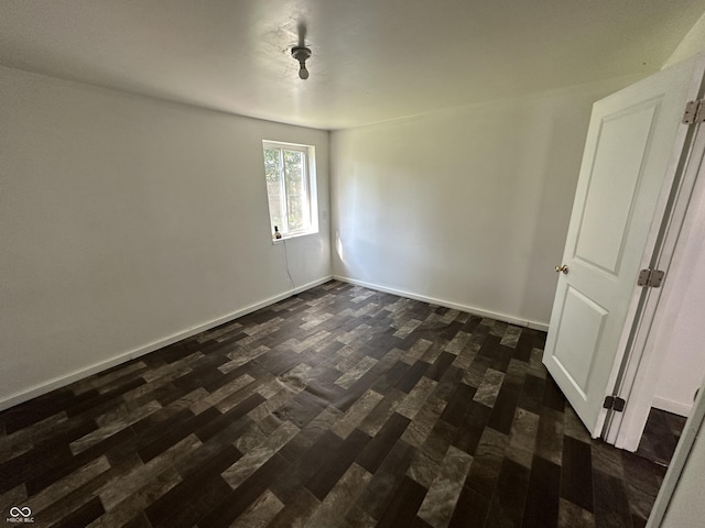 2310 E Raymond St, Indianapolis, IN 46203 - empty room with dark wood-style floors and baseboards