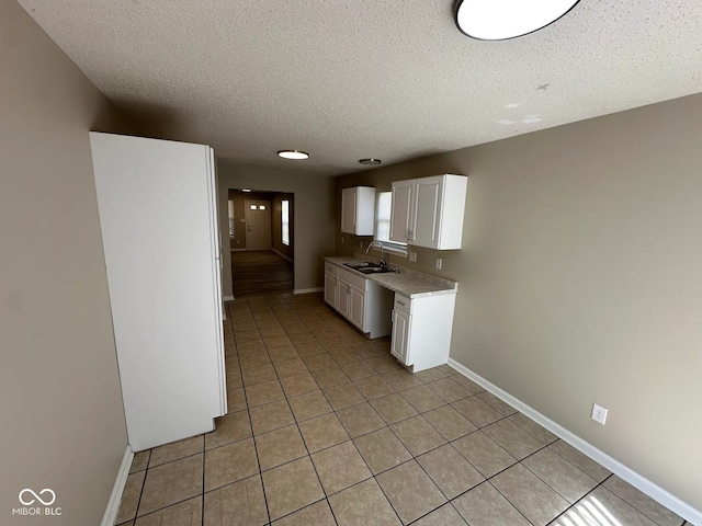 3861 Candle Berry Dr, Indianapolis, IN 46235 - kitchen featuring light countertops, light tile patterned flooring, white cabinets, a textured ceiling, and baseboards