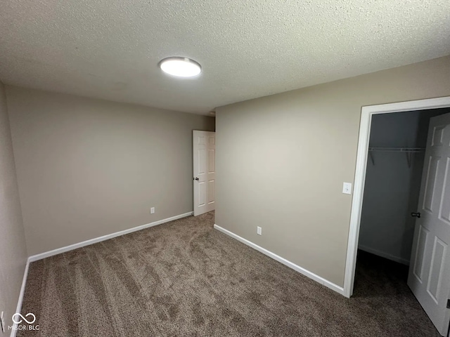 3861 Candle Berry Dr, Indianapolis, IN 46235 - unfurnished bedroom featuring carpet, baseboards, a closet, a walk in closet, and a textured ceiling