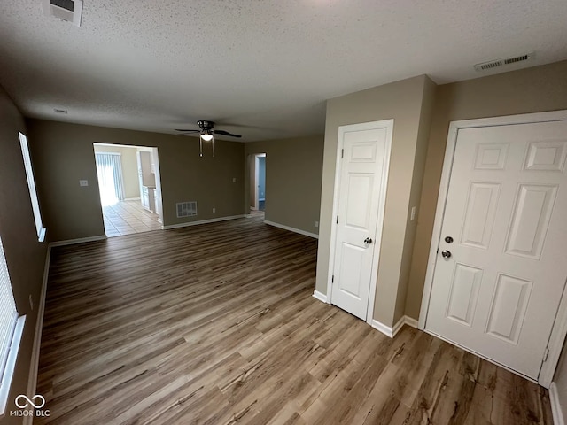3861 Candle Berry Dr, Indianapolis, IN 46235 - unfurnished living room featuring a textured ceiling, wood finished floors, ceiling fan, and baseboards