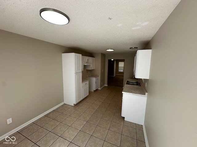 3861 Candle Berry Dr, Indianapolis, IN 46235 - kitchen with a textured ceiling, white cabinetry, baseboards, light countertops, and a sink