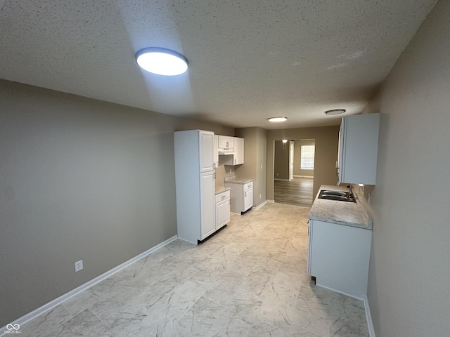 3861 Candle Berry Dr, Indianapolis, IN 46235 - kitchen with a textured ceiling, light marble finish floors, light countertops, and white cabinets
