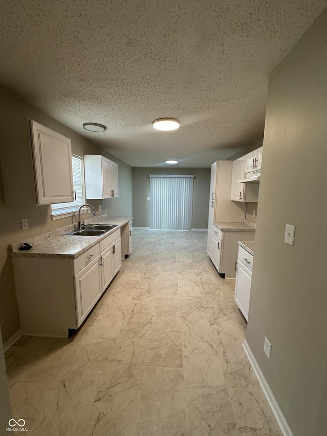 3861 Candle Berry Dr, Indianapolis, IN 46235 - kitchen featuring white cabinets, light countertops, light marble finish flooring, and a textured ceiling