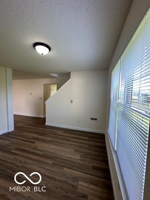 7549 Stockard St, Indianapolis, IN 46239 - empty room with a textured ceiling, dark wood-style floors, and baseboards