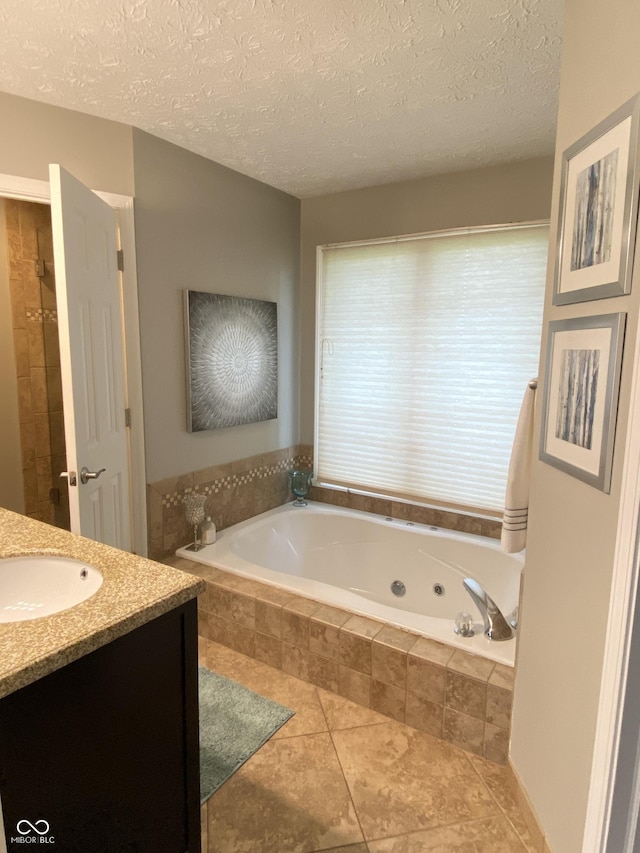 12231 Valley View Cir, Indianapolis, IN 46229 - bathroom with a tub with jets, vanity, tile patterned floors, and a textured ceiling
