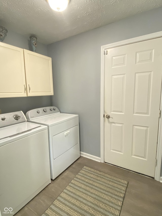12231 Valley View Cir, Indianapolis, IN 46229 - washroom featuring separate washer and dryer, cabinet space, a textured ceiling, and baseboards