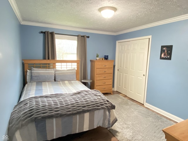 12231 Valley View Cir, Indianapolis, IN 46229 - bedroom featuring a textured ceiling, crown molding, a closet, wood finished floors, and baseboards