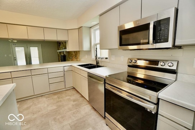 5331 Birch Ln, Greenwood, IN 46143 - kitchen with stainless steel appliances, light countertops, a sink, and a textured ceiling