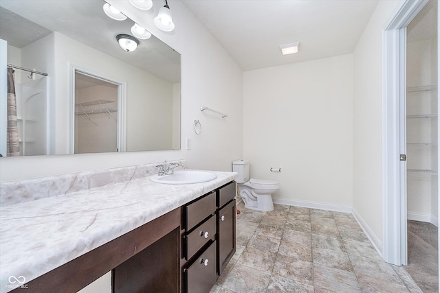 107 Elliott Ave, Trafalgar, IN 46181 - bathroom with a walk in closet, vanity, toilet, baseboards, and stone finish floors