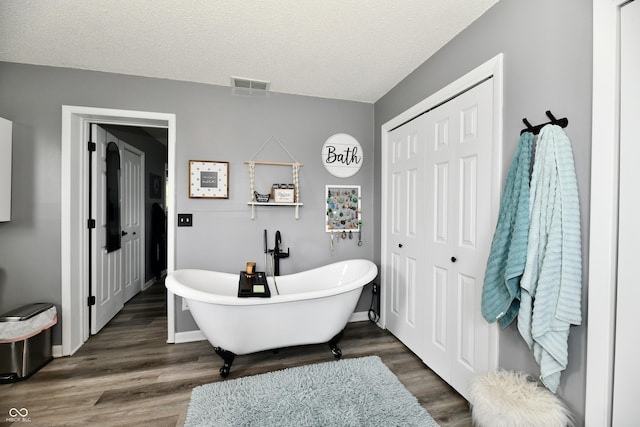 5190 N State Road 213, Windfall, IN 46076 - bathroom featuring a freestanding tub, wood finished floors, baseboards, and a textured ceiling