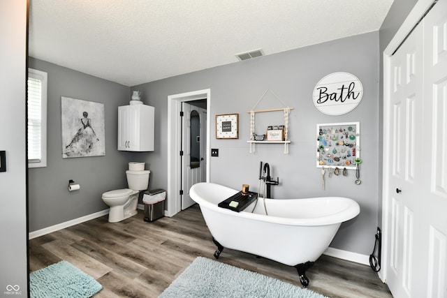 5190 N State Road 213, Windfall, IN 46076 - bathroom featuring a soaking tub, toilet, baseboards, wood finished floors, and a textured ceiling