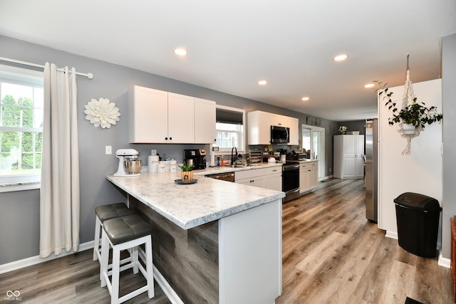 5190 N State Road 213, Windfall, IN 46076 - kitchen with stainless steel appliances, light countertops, a breakfast bar area, white cabinetry, and recessed lighting