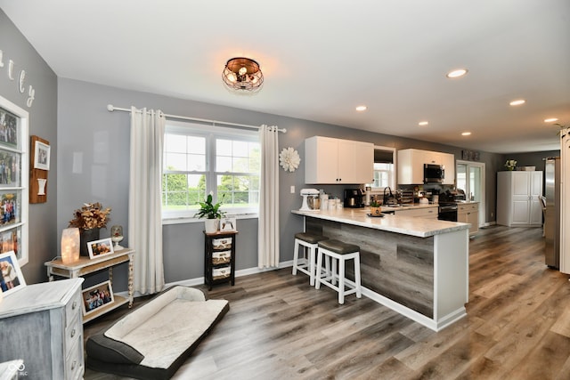 5190 N State Road 213, Windfall, IN 46076 - kitchen featuring stainless steel appliances, a sink, a peninsula, a kitchen breakfast bar, and light countertops