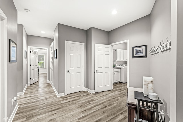 10697 Woodmont Ln, Fishers, IN 46037 - corridor with light wood-style floors, separate washer and dryer, baseboards, and recessed lighting