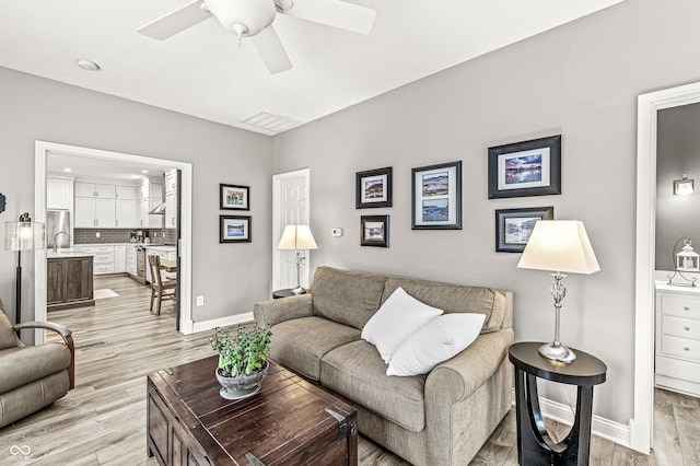 10697 Woodmont Ln, Fishers, IN 46037 - living area featuring baseboards, a ceiling fan, and light wood-type flooring