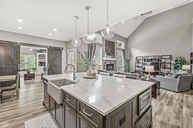 10697 Woodmont Ln, Fishers, IN 46037 - kitchen with a barn door, a sink, open floor plan, recessed lighting, and light wood-style flooring