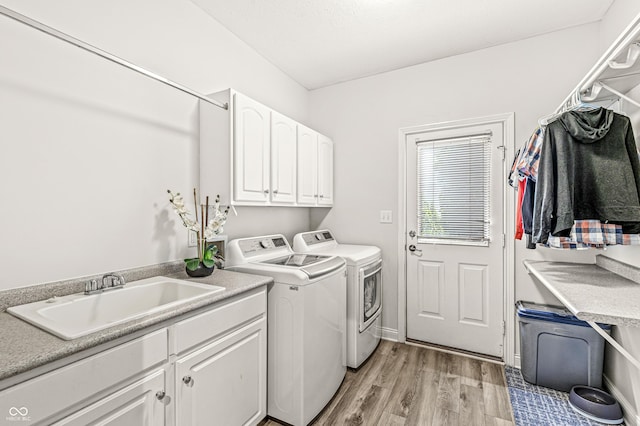 10697 Woodmont Ln, Fishers, IN 46037 - laundry area featuring washer and dryer, cabinet space, and light wood-style floors