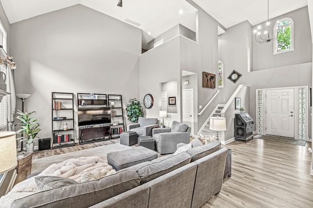 10697 Woodmont Ln, Fishers, IN 46037 - living area with high vaulted ceiling, a chandelier, stairway, light wood-style floors, and baseboards