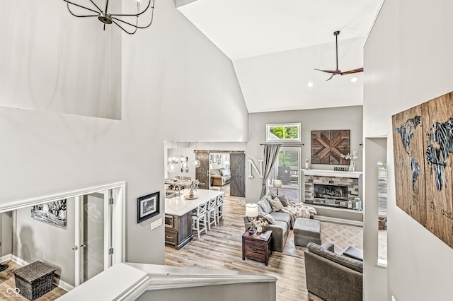 10697 Woodmont Ln, Fishers, IN 46037 - living room featuring high vaulted ceiling, a chandelier, wood finished floors, and a fireplace