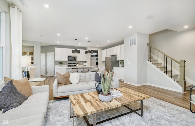 6849 Seabiscuit Rd, Whitestown, IN 46075 - living area featuring light wood-style flooring, stairs, recessed lighting, and baseboards