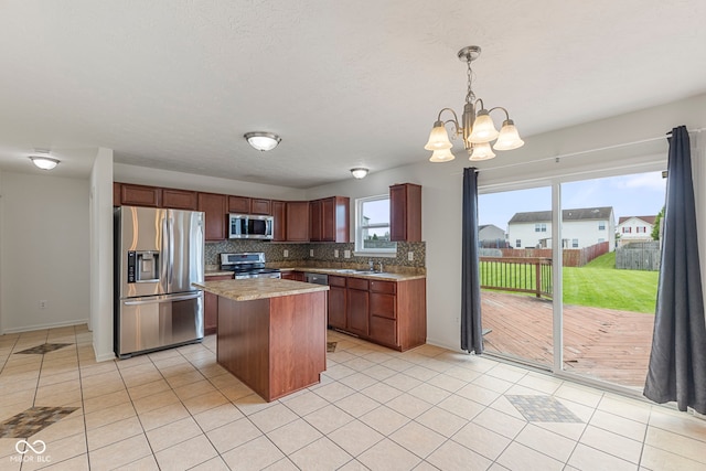 11531 Short Iron Ln, Indianapolis, IN 46235 - kitchen featuring appliances with stainless steel finishes, a sink, backsplash, a kitchen island, and a chandelier