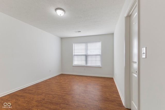 11531 Short Iron Ln, Indianapolis, IN 46235 - spare room featuring dark wood-style flooring, a textured ceiling, and baseboards