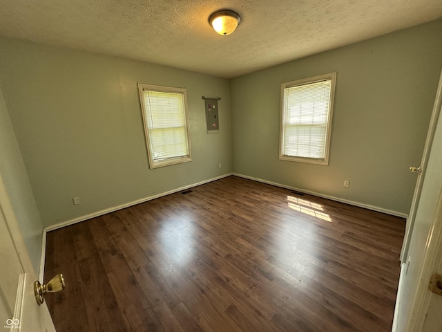 2133 10th St, Columbus, IN 47201 - unfurnished room with healthy amount of natural light, electric panel, dark wood-style flooring, and a textured ceiling