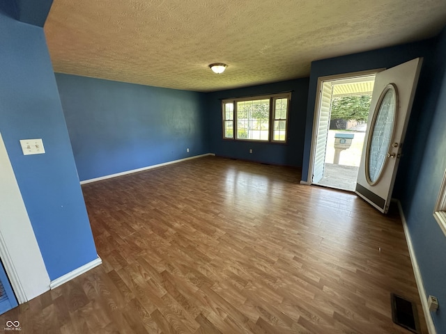 2133 10th St, Columbus, IN 47201 - unfurnished room with a textured ceiling, wood finished floors, and baseboards