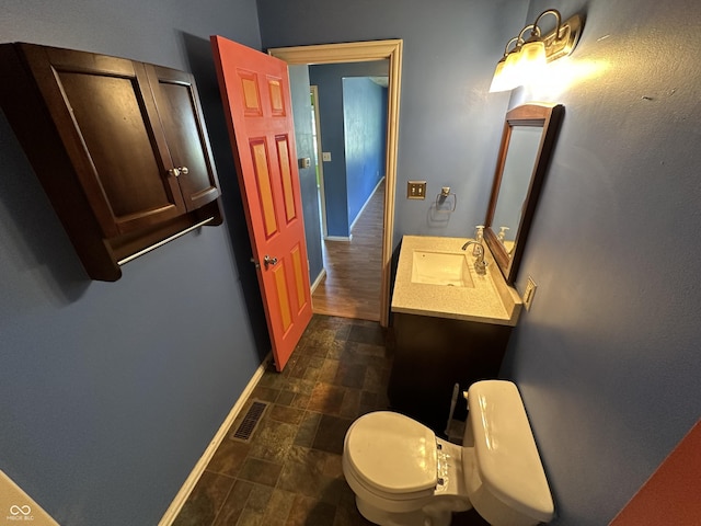 2133 10th St, Columbus, IN 47201 - half bath with stone finish flooring, baseboards, toilet, and vanity