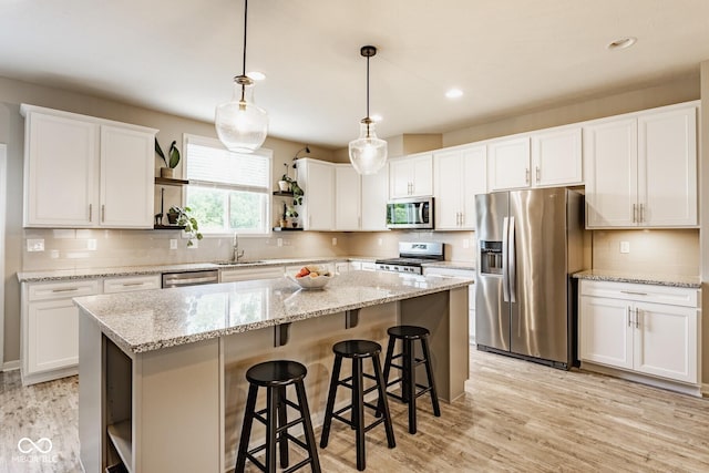 16072 Barringer Ct, Westfield, IN 46074 - kitchen with stainless steel appliances, open shelves, a kitchen island, white cabinetry, and recessed lighting