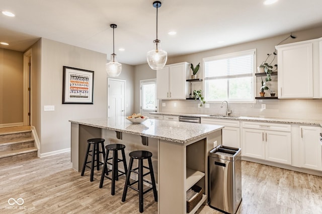 16072 Barringer Ct, Westfield, IN 46074 - kitchen with open shelves, light wood-style floors, decorative backsplash, a center island, and recessed lighting