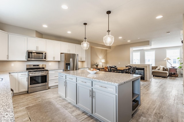 16072 Barringer Ct, Westfield, IN 46074 - kitchen with appliances with stainless steel finishes, a center island, white cabinets, light wood finished floors, and recessed lighting