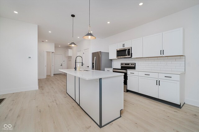 2909 E Michigan St, Indianapolis, IN 46201 - kitchen featuring stainless steel appliances, a sink, light wood-style flooring, white cabinets, and recessed lighting