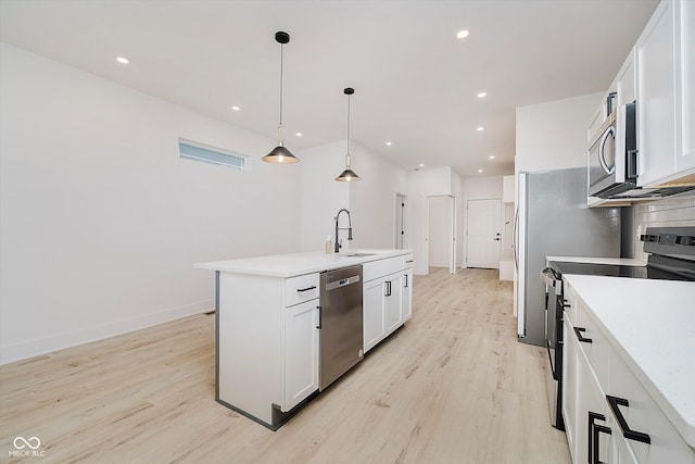 2909 E Michigan St, Indianapolis, IN 46201 - kitchen with stainless steel appliances, a sink, light wood-style floors, white cabinets, and recessed lighting