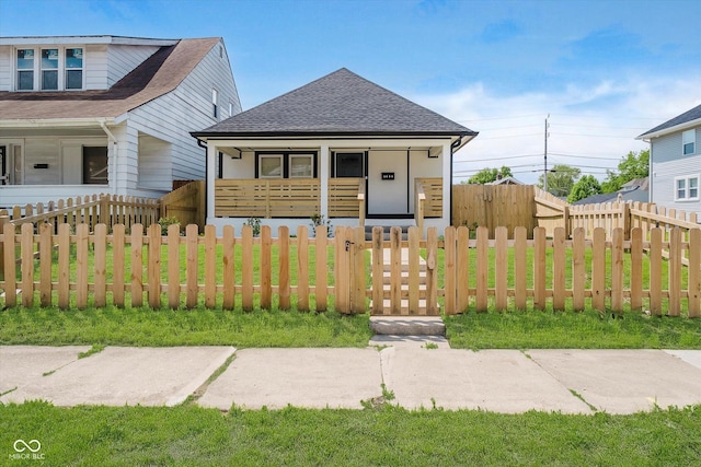 2909 E Michigan St, Indianapolis, IN 46201 - view of front of property featuring covered porch, roof with shingles, and a fenced front yard