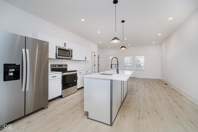 2909 E Michigan St, Indianapolis, IN 46201 - kitchen featuring stainless steel appliances, a sink, white cabinetry, light wood-style floors, and recessed lighting