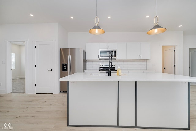 2909 E Michigan St, Indianapolis, IN 46201 - kitchen with appliances with stainless steel finishes, light wood-type flooring, white cabinets, tasteful backsplash, and recessed lighting