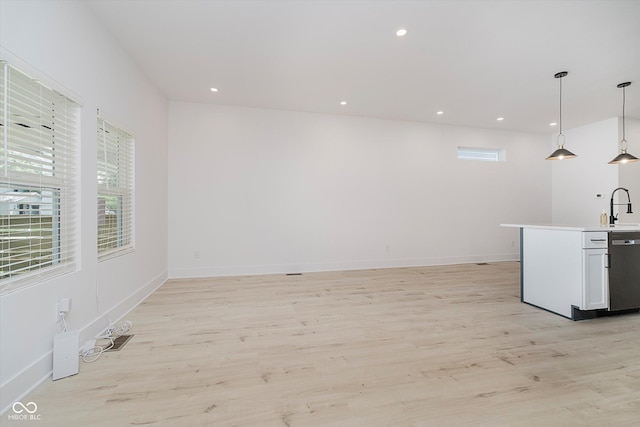 2909 E Michigan St, Indianapolis, IN 46201 - kitchen with stainless steel dishwasher, a sink, light wood finished floors, decorative light fixtures, and recessed lighting