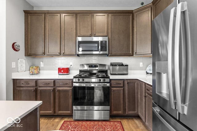 104 Perlican Dr, Cicero, IN 46034 - kitchen featuring stainless steel appliances, light wood-type flooring, tasteful backsplash, and light countertops