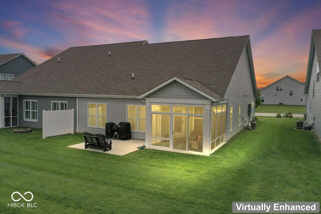 104 Perlican Dr, Cicero, IN 46034 - back of property at dusk with a patio, a lawn, roof with shingles, and central air condition unit