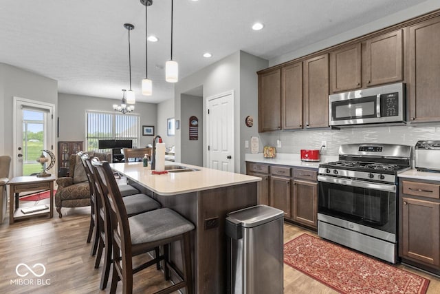 104 Perlican Dr, Cicero, IN 46034 - kitchen featuring appliances with stainless steel finishes, a sink, light wood-style floors, light countertops, and a center island with sink