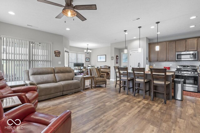 104 Perlican Dr, Cicero, IN 46034 - living room featuring wood finished floors, a ceiling fan, a chandelier, and recessed lighting