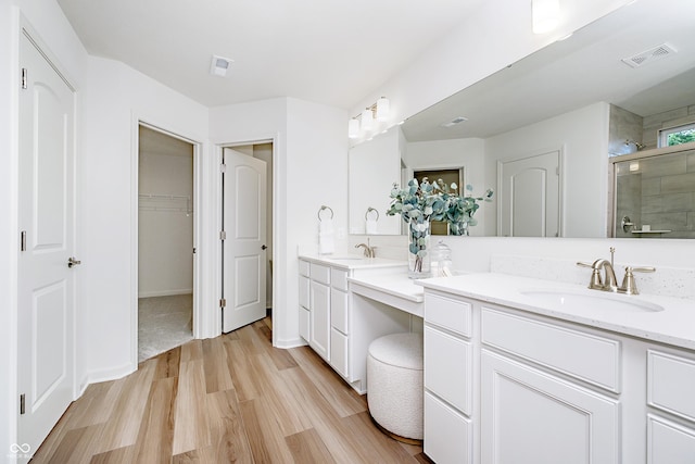 6841 Seabiscuit Rd, Whitestown, IN 46075 - bathroom with a shower stall, wood finished floors, vanity, and a walk in closet
