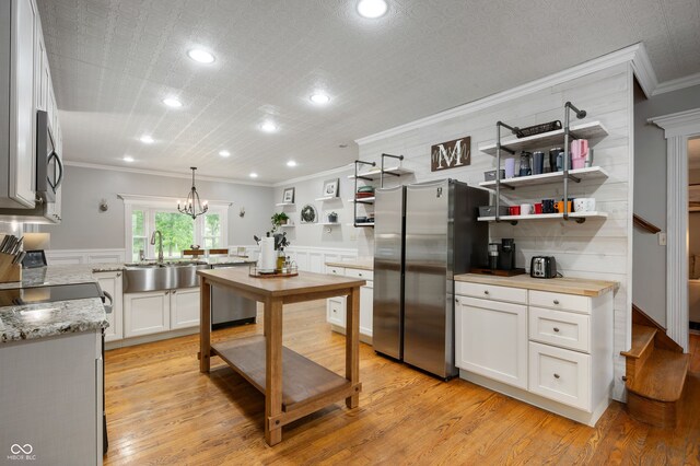 2708 N 400 E, Greenfield, IN 46140 - kitchen featuring stainless steel appliances, a sink, ornamental molding, open shelves, and light wood-style flooring