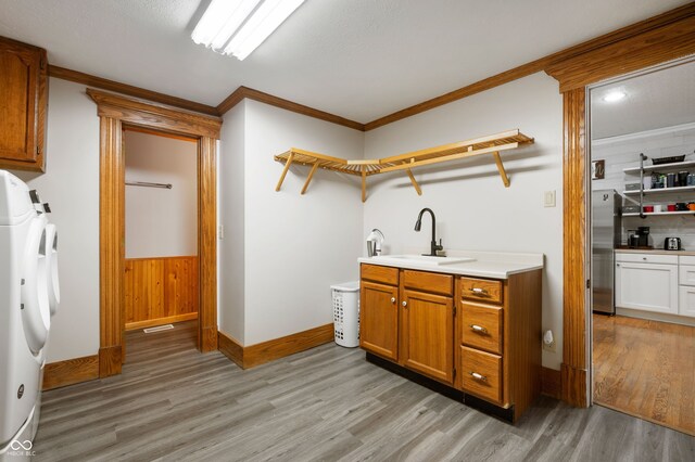 2708 N 400 E, Greenfield, IN 46140 - washroom featuring light wood-style flooring, washer and dryer, cabinet space, baseboards, and crown molding